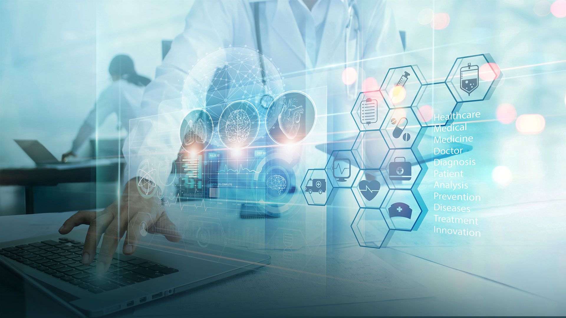 Hand einer Person an Laptop-Tastatur mit überlagernden medizinischen Symbolen und Begriffen wie Healthcare, Medical, Doctor, Diagnosis, Patient, Analysis, Prevention, Diseases, Treatment, Innovation