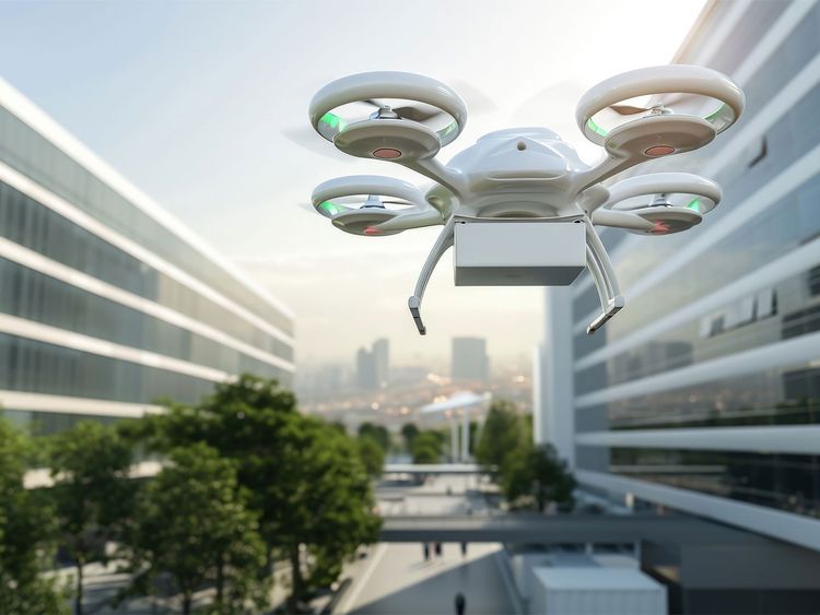 Nahaufnahme einer weißen Drohne mit vier Rotoren vor unscharfem Stadtgebäude-Hintergrund