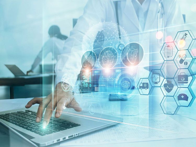 Hand einer Person an Laptop-Tastatur mit überlagernden medizinischen Symbolen und Begriffen wie Healthcare, Medical, Doctor, Diagnosis, Patient, Analysis, Prevention, Diseases, Treatment, Innovation