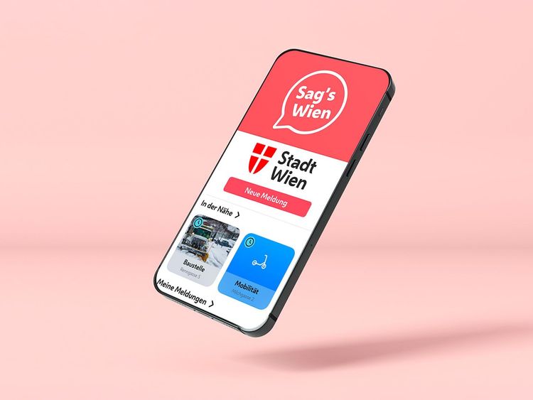Smartphone mit geöffneter App "Sag's Wien" der Stadt Wien auf rosa Hintergrund